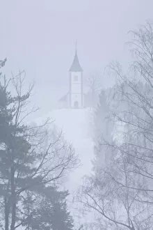 Church of St. Primoz on a foggy winters day, Jamnik region, Slovenia