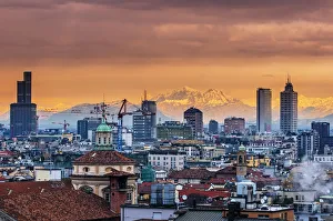 Industrial Prints: City skyline at sunset with the snowy Alps in the background, Milan, Lombardy, Italy