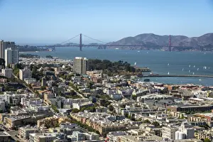 Cityscape near famous Golden Gate Bridge against blue sky on sunny day, San Francisco