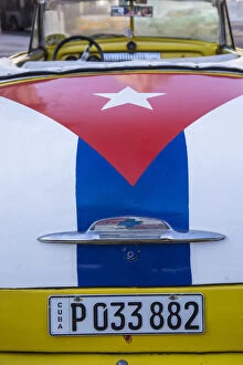 Automobile Gallery: Classic American car with the Cuban flag painted in its boot, Parque Central