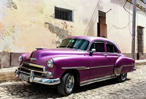 Trinidad Prints: Classic American car parked on a cobbled street in the historic centre of Trinidad