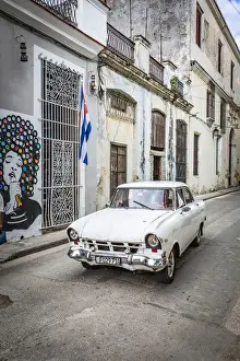 Habana Prints: Classic car driving in a narrow street in La Habana Vieja (Old Town), Havana, Cuba