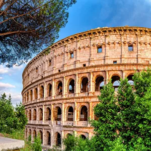 Latium Prints: Clear sky at sunset over Coliseum surrounded by lush trees, Rome, Lazio, Italy