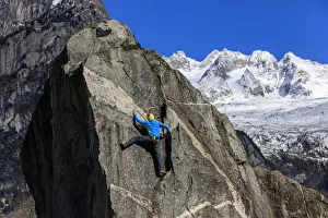 Climber on steep rock face in the background blue sky and snowy peaks of the alps Climber on steep rock face in the background blue sky and snowy peaks of the alps