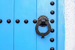 Alley Prints: Close up of blue knobbed doorway on white wall background in the old alleys of Medina