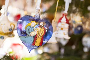 a close up image of a glass heart rappresenting the Holy Family in the Christmas market