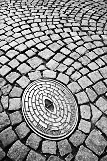 Cobbled Street Prints: Close-up deatil showing cobbled street and manhole cover, Ljubljana, Slovenia