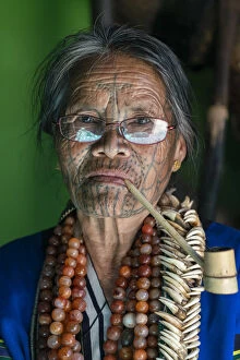 Burma Gallery: Close-up portrait of old lady with glasses and traditional facial tattoo smoking a pipe