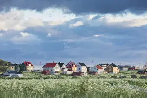 Lofoten Archipelago Prints: Clouds and midnight sun frames the typical houses of the fishing village Eggum Unstad Vestvagoy Lofoten Islands Norway