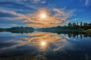 Clouds at sunrise reflected in Winnipeg River Kenora, Ontario, Canada