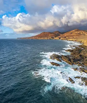 Surf Prints: Clouds at sunset on breaking waves at Playa de la Solapa beach, aerial view, Pajara