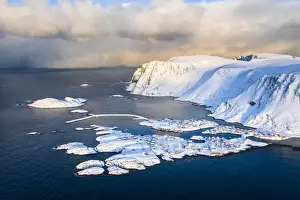 Snow Covered Prints: Coastal village of Sorvaer covered with snow during sunrise in the cold arctic winter (Soroya Island)