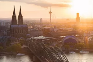 Cologne Cathedral at sunset and Hohenzoller Bridge over River Rhine in Cologne city
