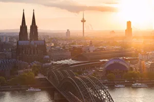 Cologne Cathedral at sunset and Hohenzoller Bridge over River Rhine in Cologne city Cologne Cathedral at sunset and Hohenzoller Bridge over River Rhine in Cologne city