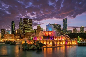 Trending: Colored-light show at Buckingham Fountain with city skyline in the backdrop, Chicago, Illinois, USA