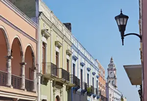 Colorful houses in colonial architecture on a street in the historic center of Campeche with the cathedral in the background, Yucatan, Mexico