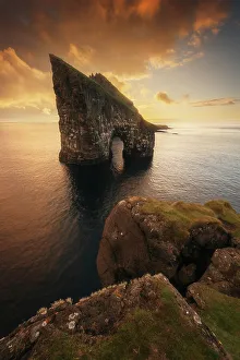 Coast Line Prints: Colorful sunset behind the cliffs of Drangarnir after the storm cleared
