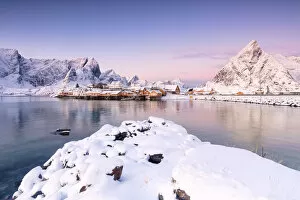 The colors of dawn frames the fishermen houses surrounded by snowy peaks SakrisAA┬©y