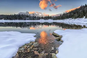 The colors of dawn on the snowy peaks and woods reflected in PalA'A¹ Lake Malenco Valley Valtellina Lombardy Italy Europe