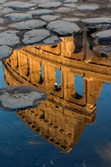 Colosseum or Coliseum reflected in a puddle at sunset, Rome, Lazio, Italy