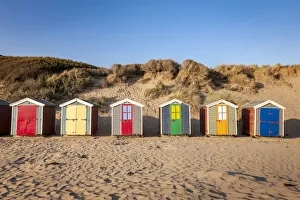 Sand Dunes Prints: Colourful beach huts on Saunton Sands beach, Devon, England