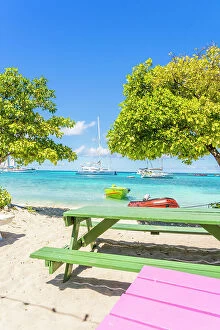 Images Dated 6th April 2023: Colourful benches at an ouitdoor restaurant, Petit Rameau Island part of the Tobago Cays in