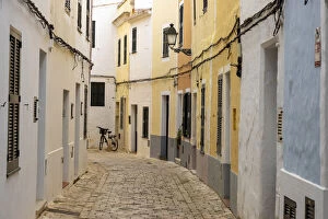 Images Dated 16th December 2021: Colourful buildings line a narrow street in the old town of Ciutadella, Ciudadela