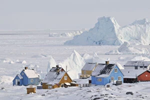 Images Dated 3rd November 2014: Colourful row of houses with icebergs in the background, Qeqertarsuaq, Disko Island