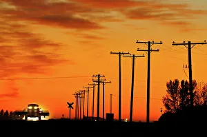 Saskatchewan Prints: Combine moving down the road at sunset Tuxford, Saskatchewan, Canada