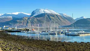 Hillside Prints: Corpach lighthouse and marina on the shores of Loch Eli with snow capped Ben Nevis and Fort William