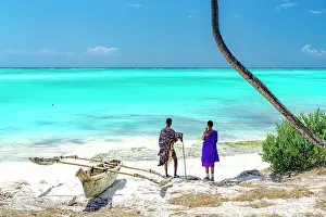 Dhow Prints: Couple of Maasai with dhow admiring the crystal turquoise sea standing on a white coral beach