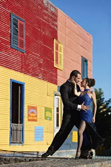 Performance Gallery: A couple of Professional Tango dancers with a colorful house of La Boca neighborhood in