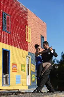 A couple of Professional Tango dancers with a colorful house of La Boca neighborhood in the background, Buenos Aires, Argentina. (MR)