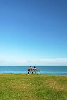 Bench Prints: A couple sitting on a bench, enjoying a sea view over Tankerton Beach