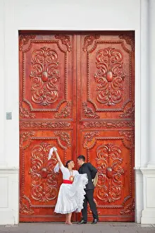 A couple of traditional Marinera'dancers in front of a colonial architecture door in the Plaza de Armas'of Trujillo, La Libertad, Peru. Marinera is the Peruvian National dance. (MR)