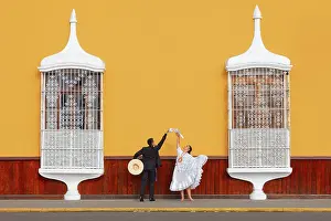 A couple of traditional Marinera'dancers in front of colonial architecture windows of the Plaza de Armas'in Trujillo, La Libertad, Peru. Marinera is the Peruvian National dance. (MR)