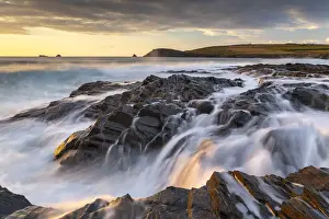 Crashing waves over the rocky shores of Boobys Bay at sunset on the North Cornwall