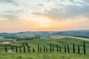 Crete Senesi, Tuscany, Italy. A lonely farmhouse with cypress and olive trees, rolling hills