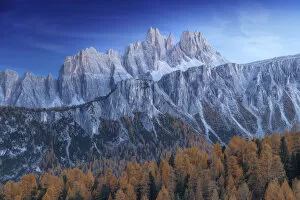 The Croda da Lago and Lastoi de Formin mountains at twilight, with the golden larches glowing in the darkness