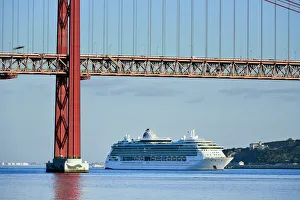 Images Dated 2nd December 2016: A cruise ship in the Tagus river, leaving the port of Lisbon, passes beneath the 25