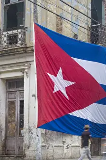 Cuba, Huge Cuban flag hanging across buildings in a street in Santa Clara, after