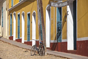 Cuba, Trinidad, Bike leaning against lamp post by colourful houses