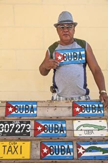Seller Gallery: Cuba, Trinidad, Man selling Cuban car number plates