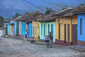 Cobblestones Prints: Cuba, Trinidad, A man selling sandwiches blows a whistle as he walkes up a Colourful