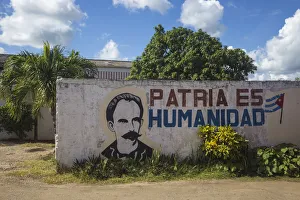 Revolution Prints: Cuba, Villa Clara province, Remedios, Bus station, Revolutionary slogan painted on wall