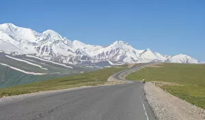 Kyrgyzstan Gallery: Cyclist along Irkestam pass road with Pamir peaks in the background
