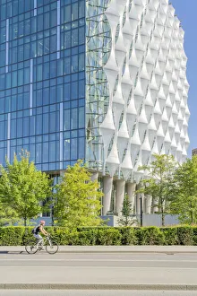 Bicycle Gallery: Cyclist riding past The American embassy in London, Nine Elms, London, England, UK