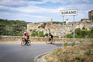 Two People Prints: Two cyclist on the road towards the old town of Sorano, province of Grosseto, Tuscany