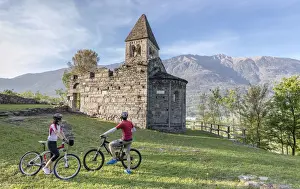 Bicycles Prints: Cyclists admire the ancient Abbey of San Pietro in Vallate in spring Piagno Sondrio