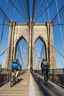 Bikes Prints: Cyclists riding their bikes on Brooklyn Bridge, New York, USA